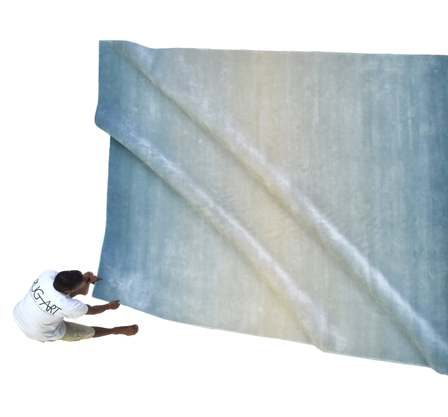 ombre colored hand made rug in blue and white.
