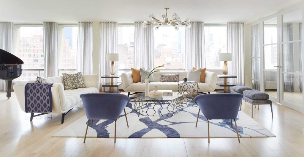 abstract design rug in white and blue colors, in a light filled and bright new york living room.